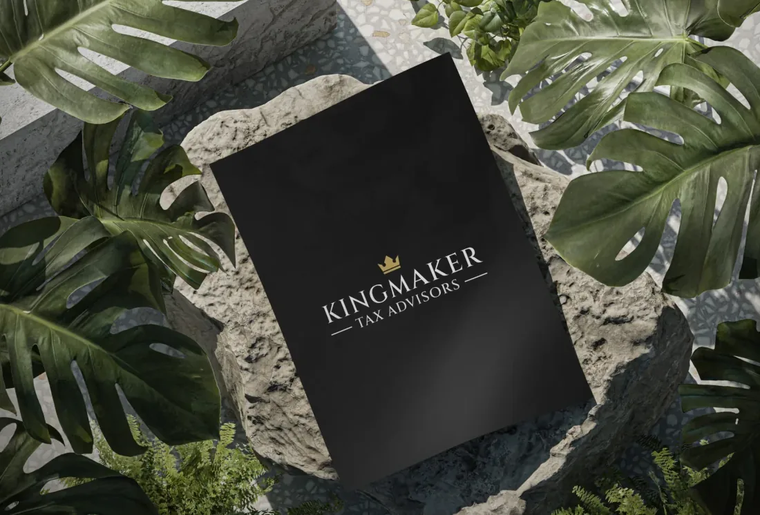Kingmaker Tax Advisors black presentation folder among leaves.